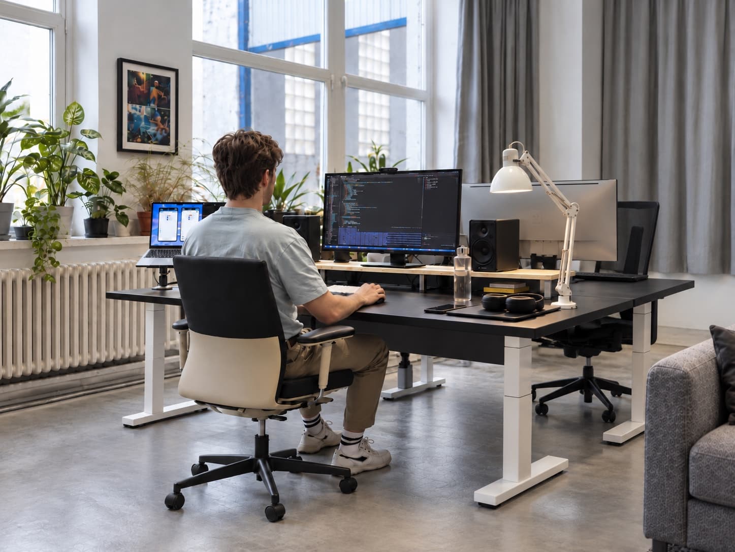 Jakub Smolík při práci u stolu s monitorem a notebookem